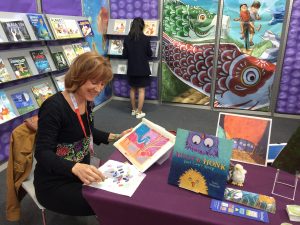 Illustrator Leslie Helakoski doing an art demo and book showcase in the SCBWI booth at the Bologna Book Fair